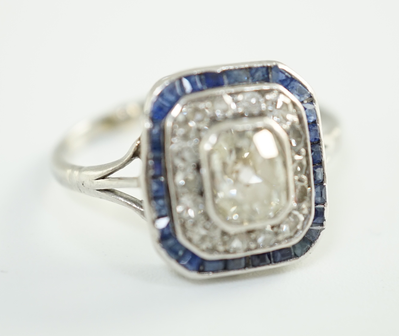 An Art Deco platinum, diamond and sapphire set rectangular cluster ring